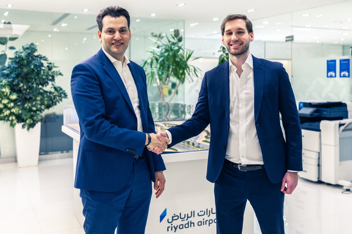 Michał Zieliński shaking hands with a Riyadh Airports executive in the company's Riyadh office.
