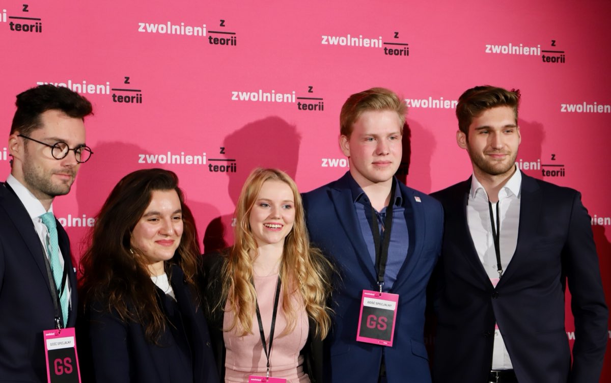 Michał Zieliński with other guests at the Zwolnieni z Teorii event backdrop.